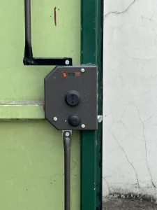 Serrure de porte de box avec tringle déporté