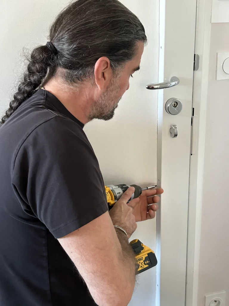 Photo du serrurier avec sa visseuse qui fait un dépannage